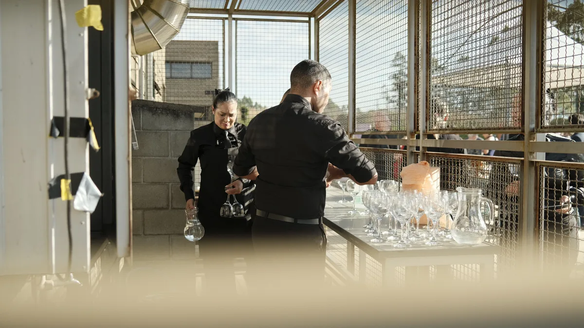 Catering staff preparing glassware for an event
